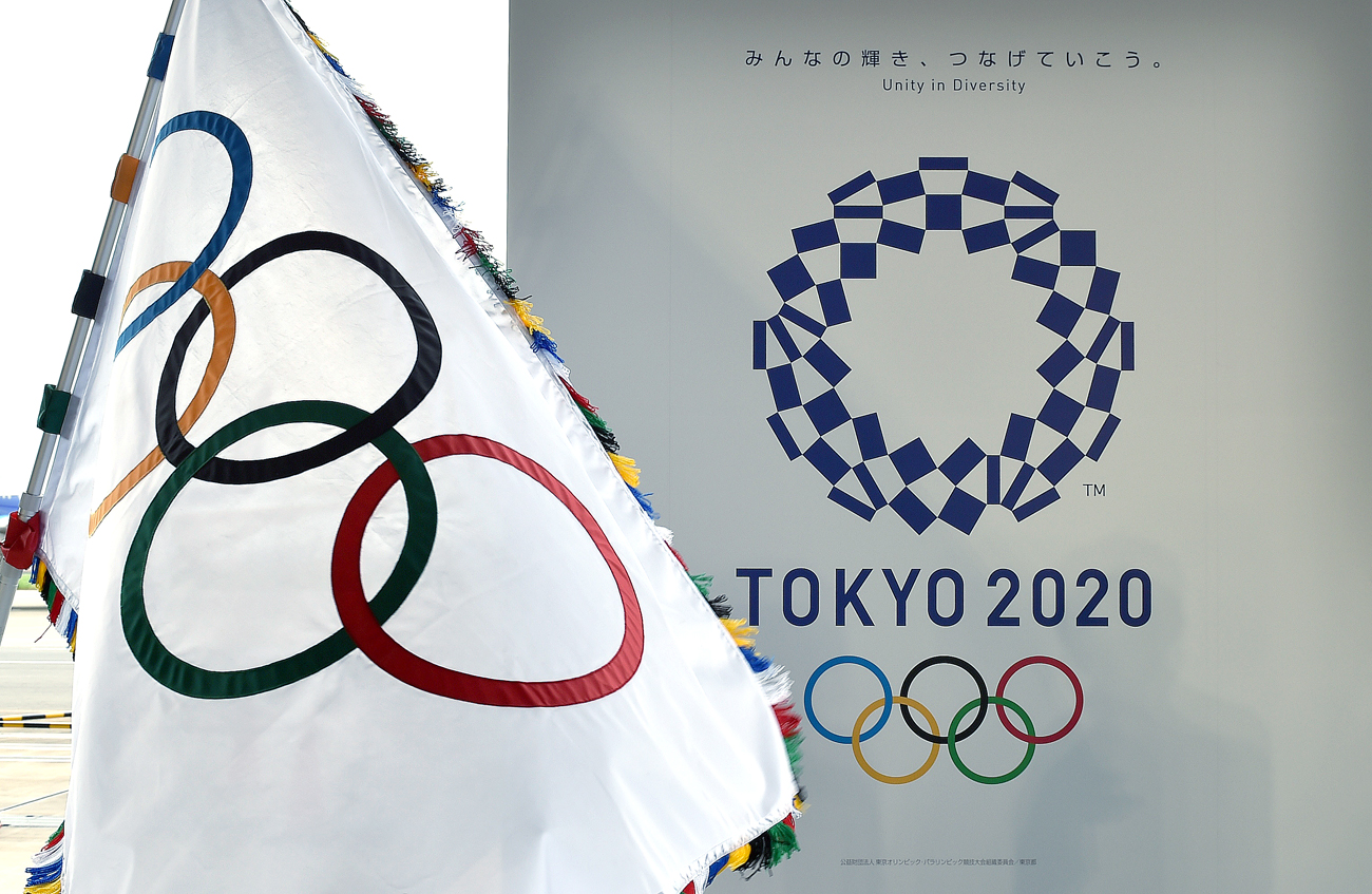 The Olympic flag (L) and the logo of the Tokyo 2020 are displayed during the official flag arrival ceremony at the Tokyo's Haneda airport.