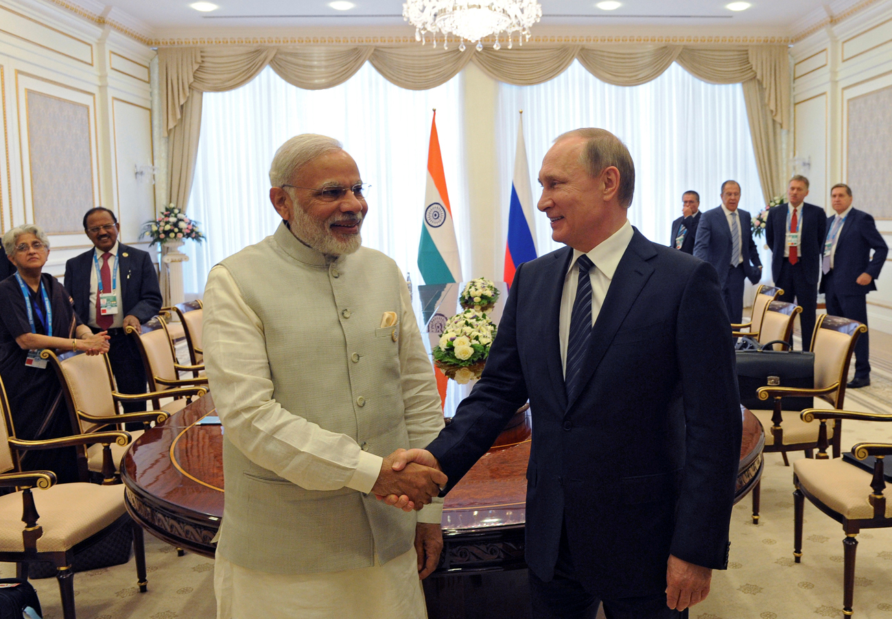 PM India Narendra Modi (kiri) berjabat tangan dengan Presiden Rusia Vladimir Putin pada KTT SCO di Tashkent, Uzbekistan, 24 June 24 2016. 