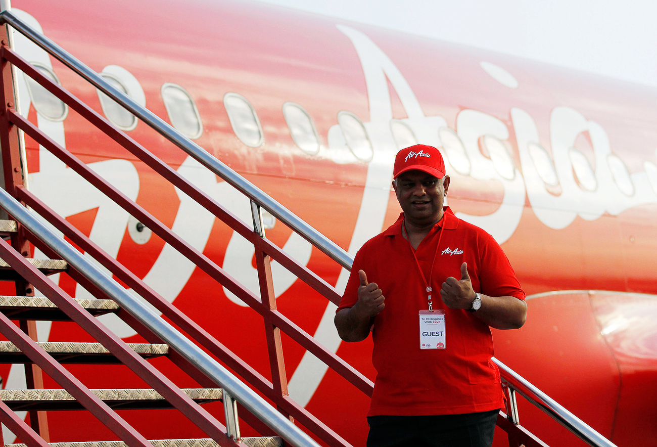 Tony Fernandes, CEO of AirAsia, gestures before boarding a AirAsia Airbus A320 plane at the domestic airport in Manila.
