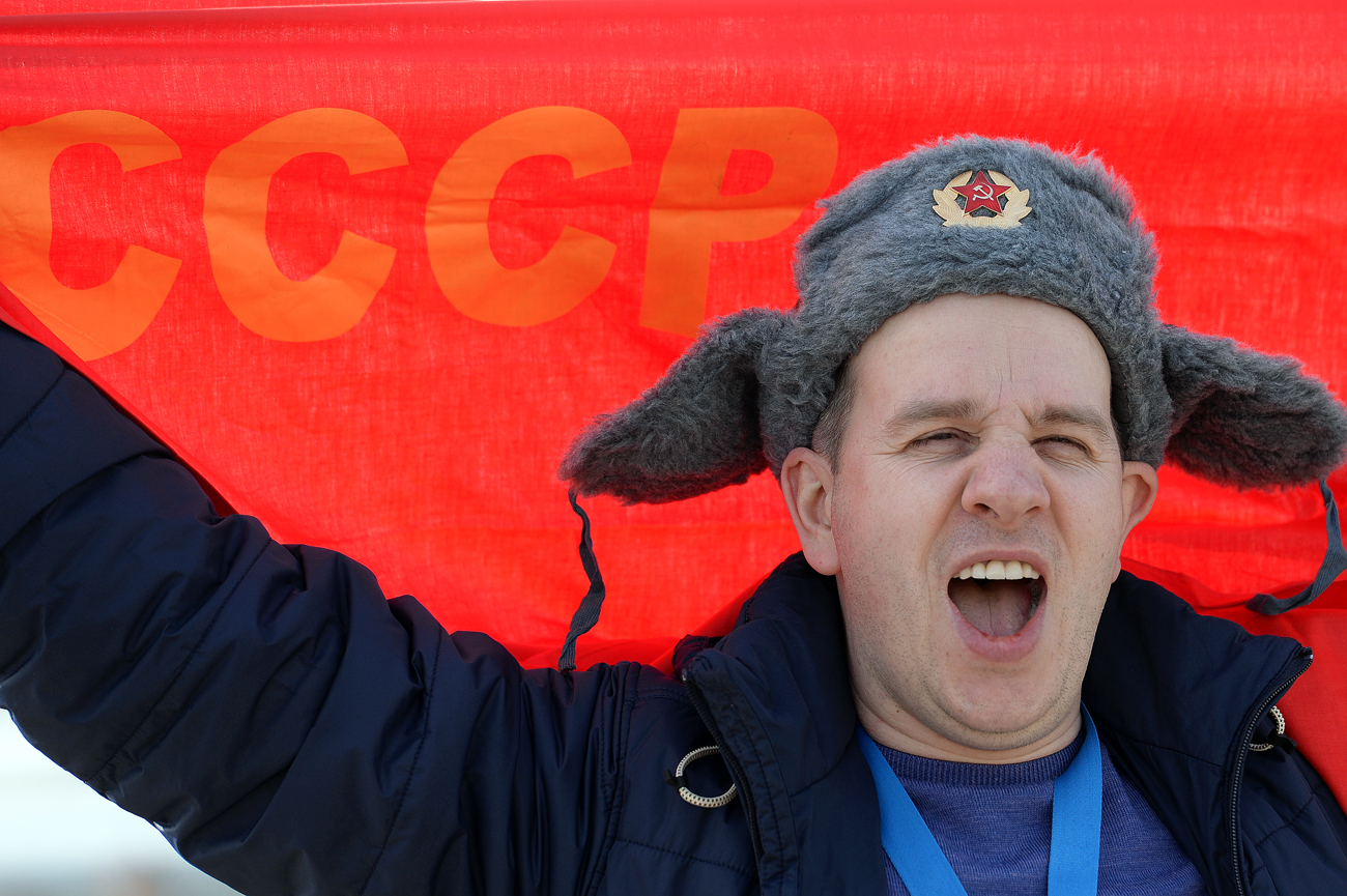 Seorang penggemar olahraga Rusia dengan bendera bertuliskan "CCCP" (SSSR), yang merupakan singkatan negara Uni Soviet dalam bahasa Rusia, di Taman Olimpiade, Sochi.