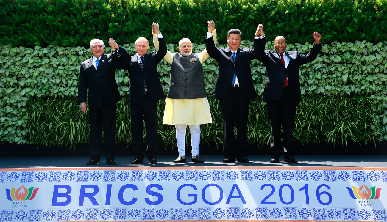 Leaders of BRICS countries: (L-R) Brazilian President Michel Temer, Russian President Vladimir Putin, Indian Prime Minister Narendra Modi, Chinese President Xi Jinping, and South African President Jacob Zuma raise their hand for a group photo at the start of their summit in Goa, India, on Oct. 16, 2016. 