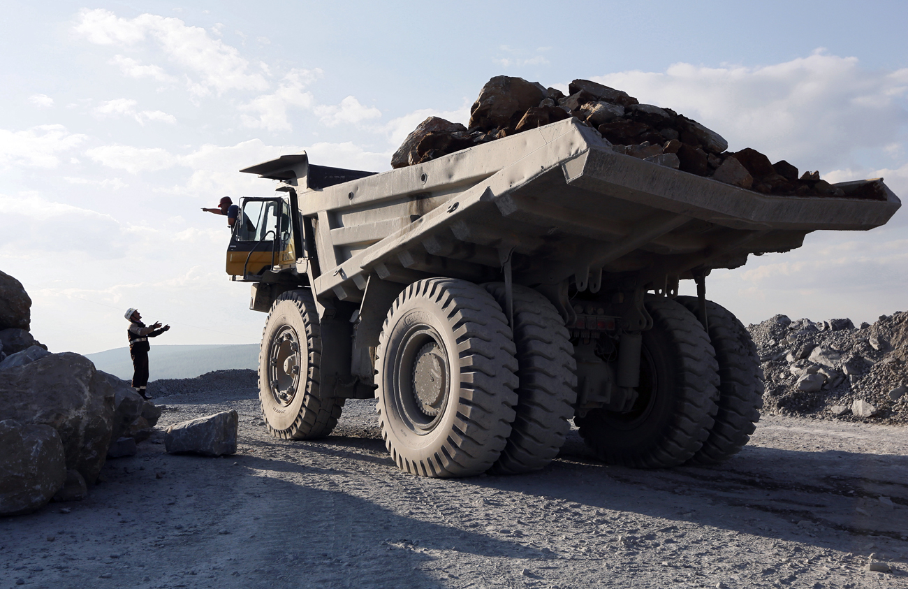 An engineer talks to a driver of a dump truck loaded with gold-bearing soil at the Vostochny opencast of the Olimpiada gold operation, owned by Polyus Gold International company, in Krasnoyarsk region.