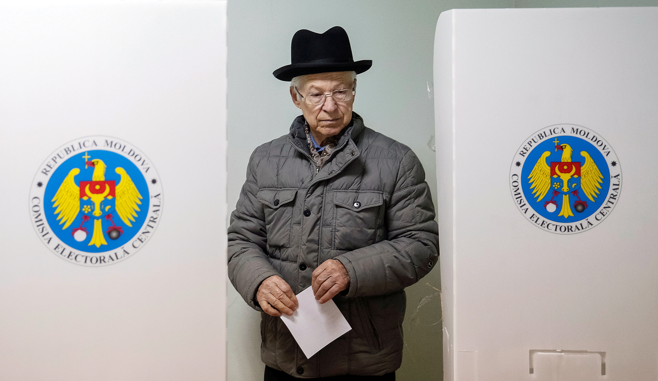 A man leaves a booth before casting his vote during a presidential election at a polling station in Chisinau, Moldova