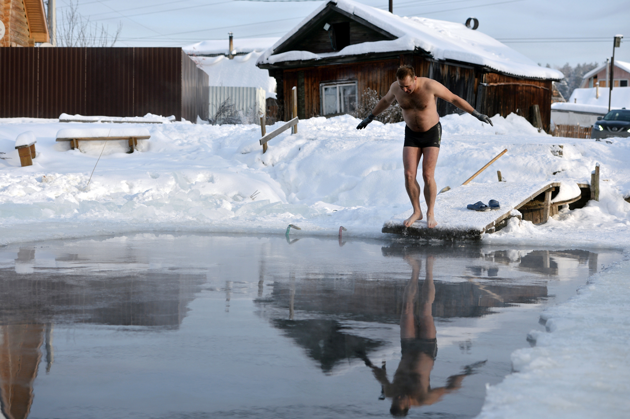 Член на клубот „Поларна мечка“ се подготвува да скокне во базен во Екатеринбург, Русија.