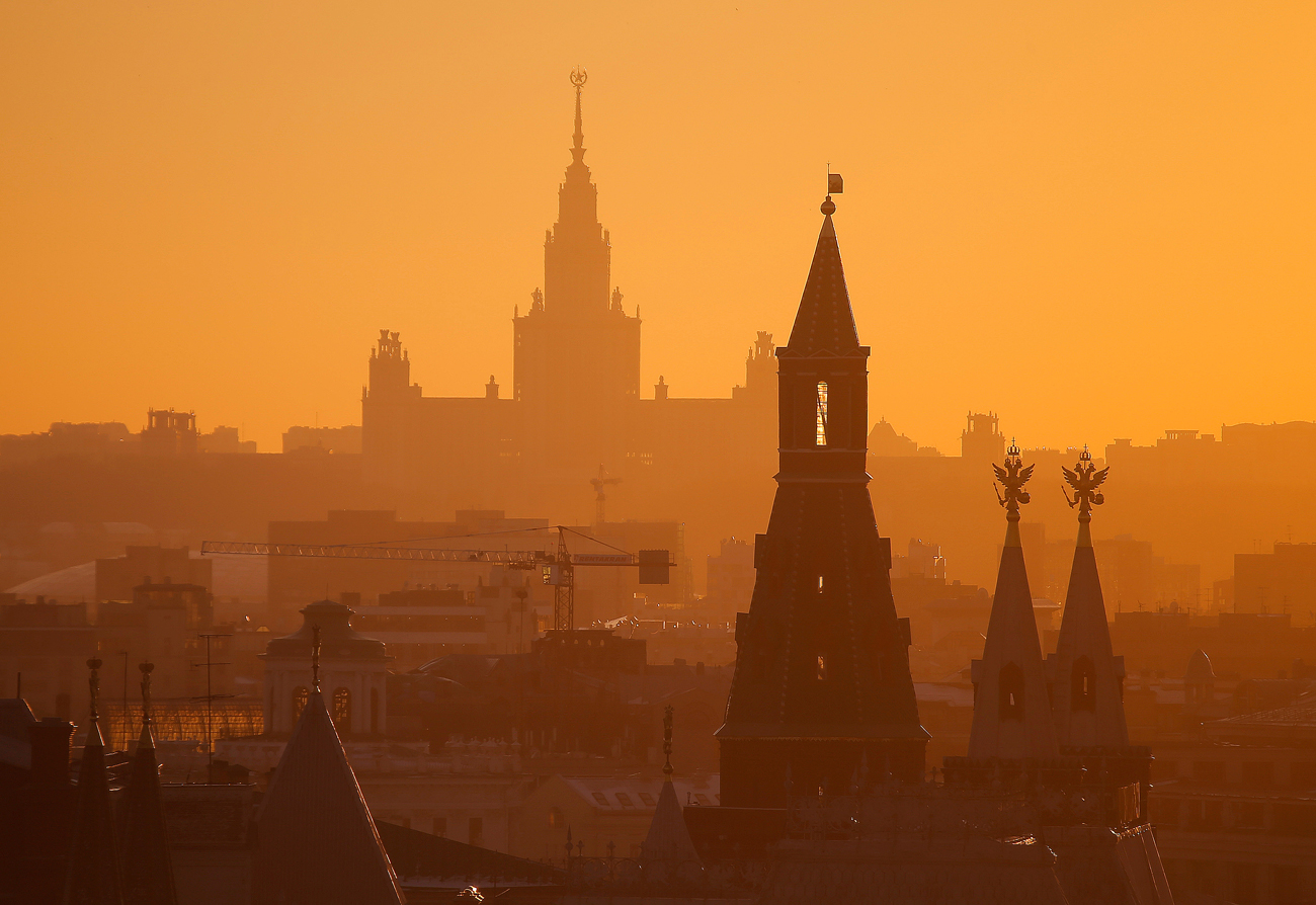 Поглед на главната зграда на Московскиот државен универзитет „Ломоносов“ (во позадина) и една од кулите на Кремљ (напред) додека сонцето заоѓа во Москва, Русија. 