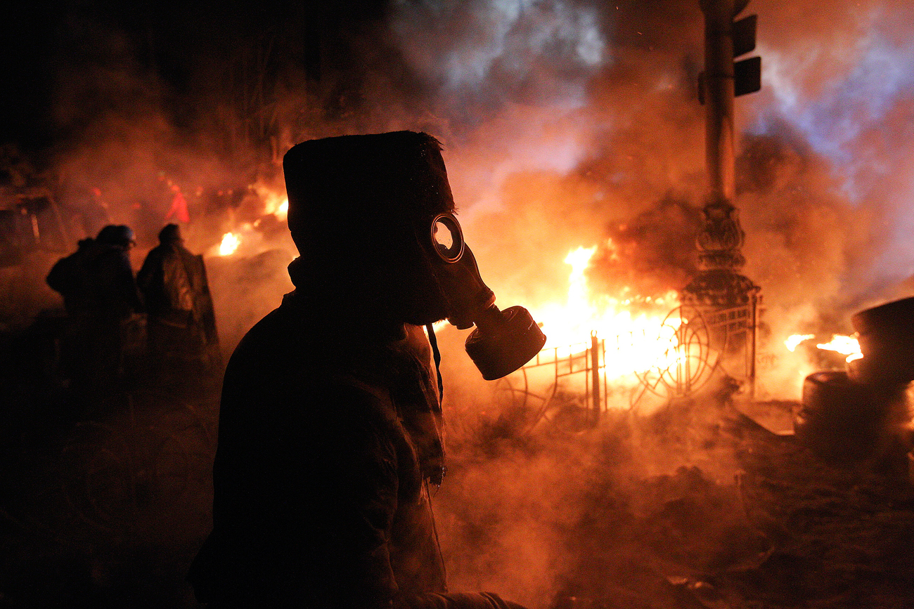 Anti-government protesters gather at a barricade at the site of clashes with riot police in Kiev.