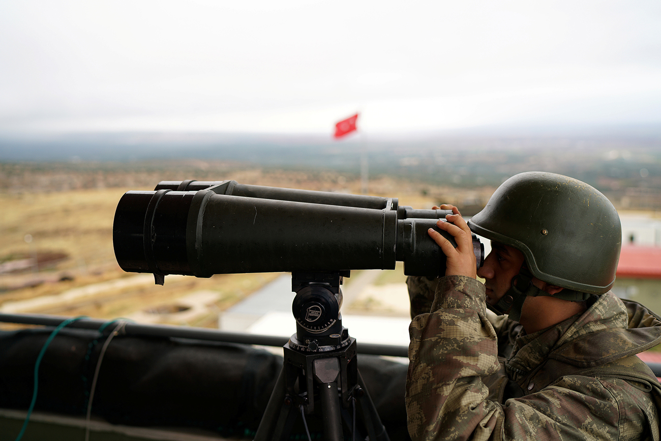 A Turkish soldier watches the border line between Turkey and Syria near the southeastern village of Besarslan, in Hatay province, Turkey.