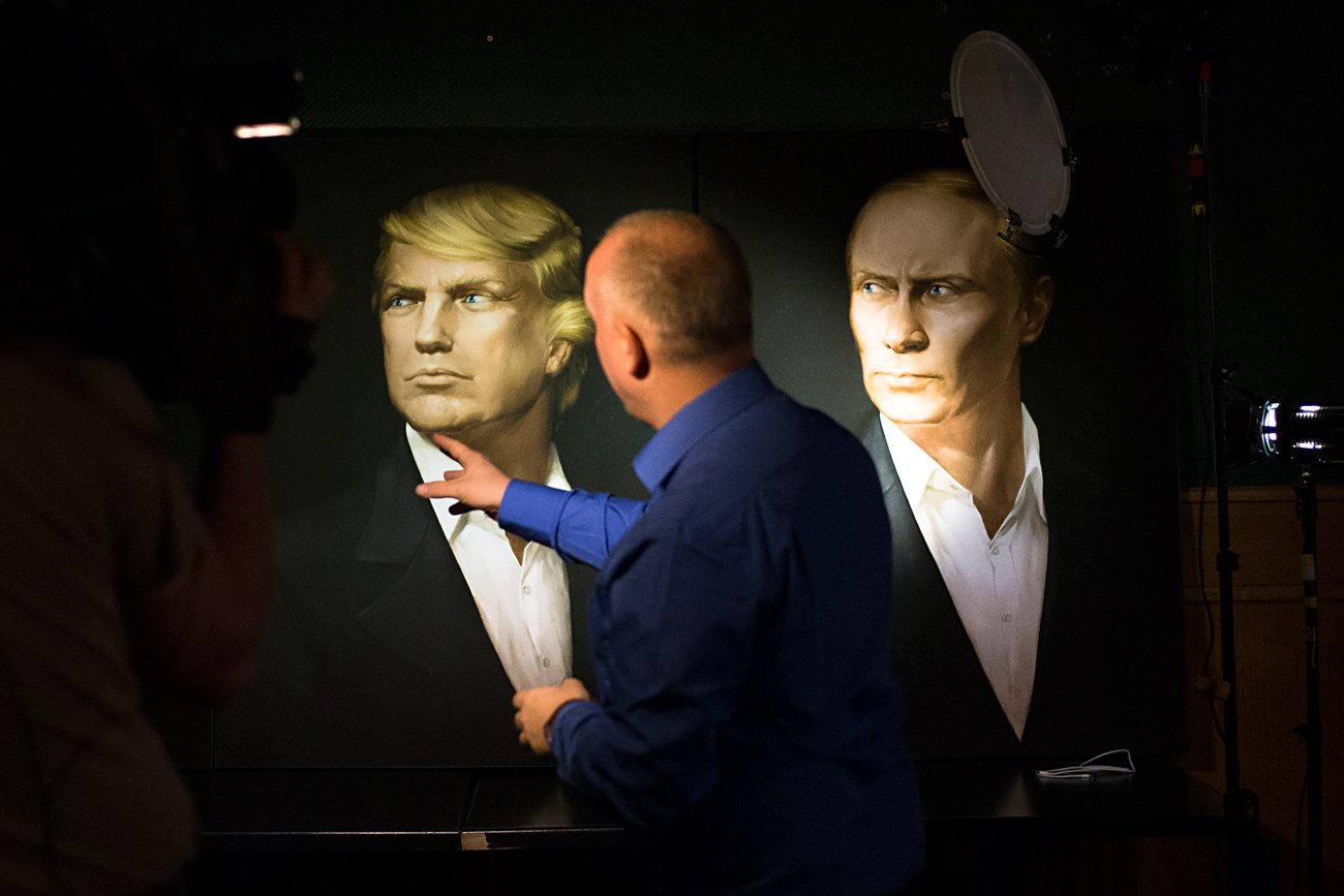 A journalist points at a portrait of U.S. President-elect Donald Trump, with a portrait of Russian President Vladimir Putin during a live telecast of the U.S. presidential election in the Union Jack pub in Moscow, Russia.