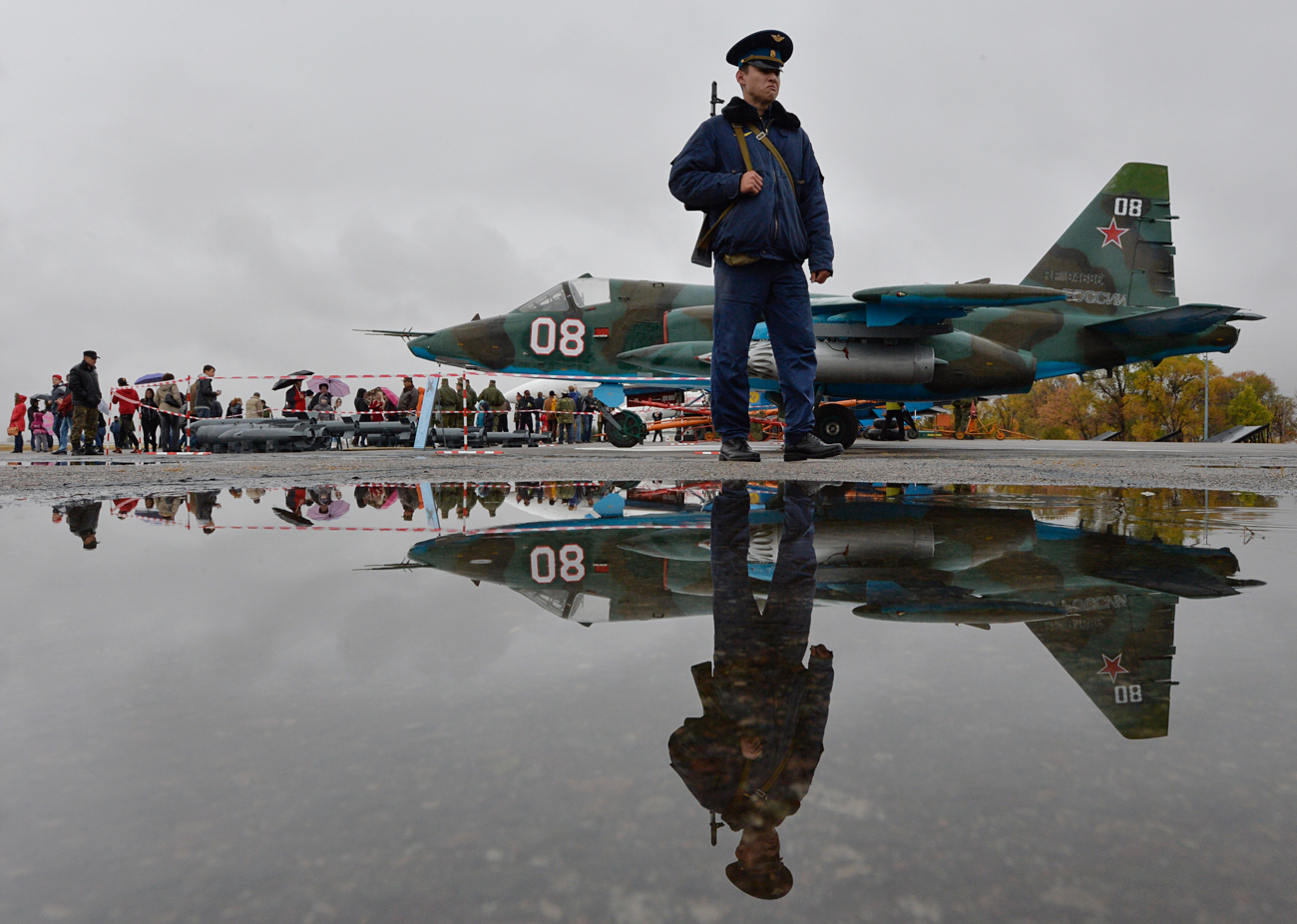 In this photo taken on Oct. 27, 2013, a Russian officer guard patrols at Kant, a Russian air base, outside Bishkek, Kyrgyzstan, with a Su-25 ground attack jet parked is in background. 