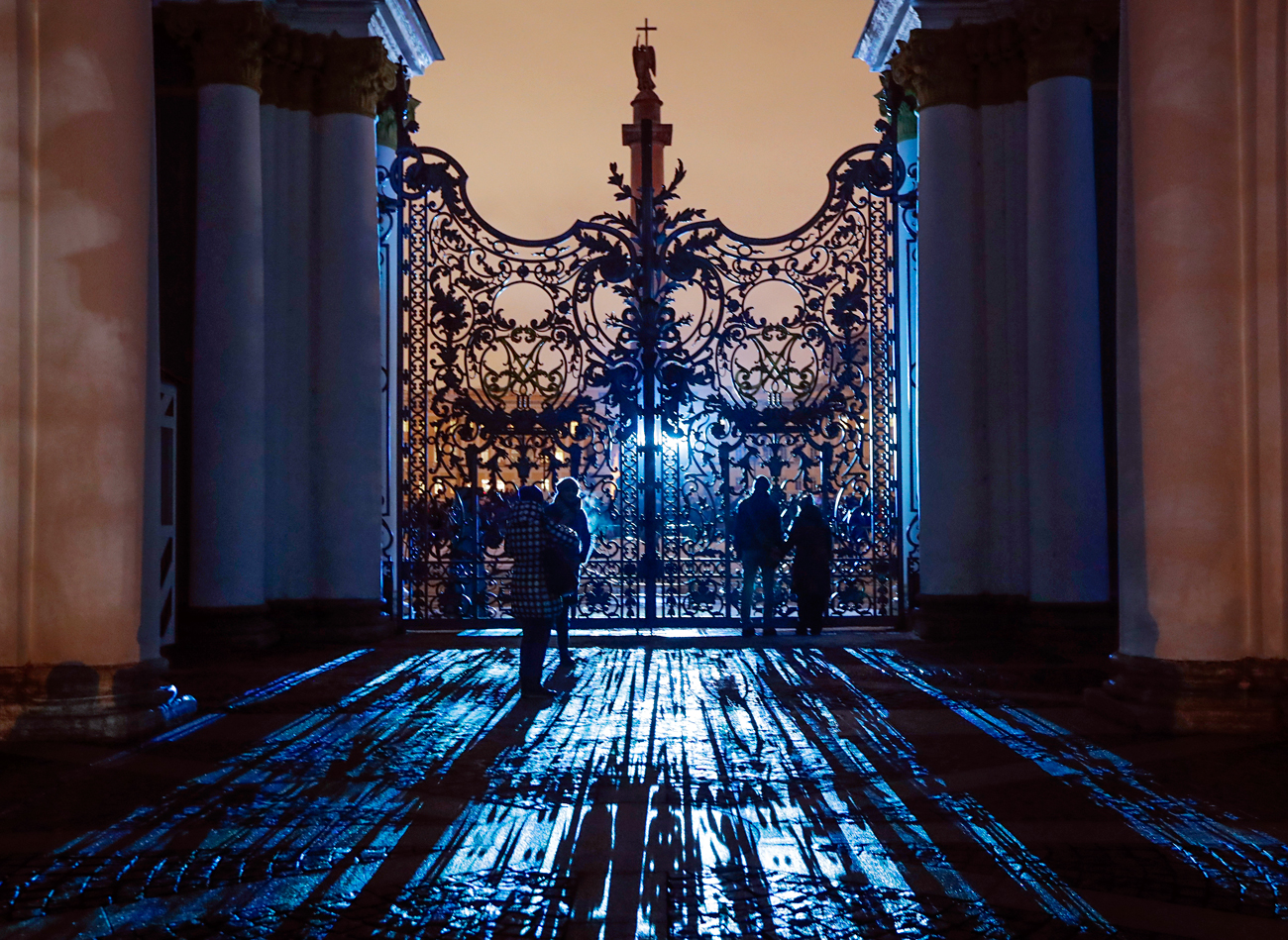 People look at illuminated Hermitage State Museum through the main gate during a light show marking the Day of Hermitage at the Dvortsovaya (Palace) square in St. Petersburg, Russia, Wednesday, Dec. 7, 2016. 