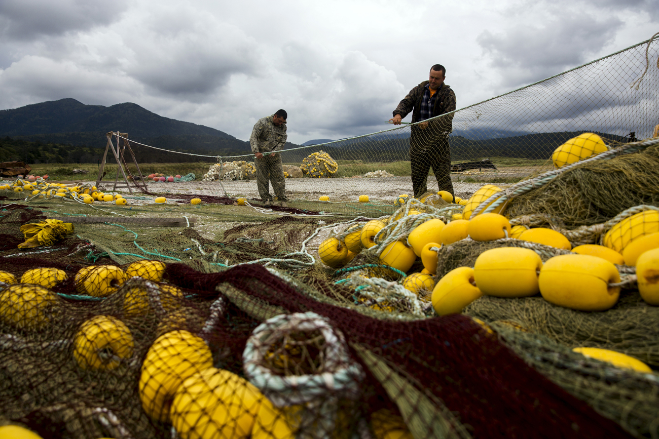 Ribari popravljaju mreže na obali Ohotskog mora na južnom Kurilskom otoku Kunašir / 