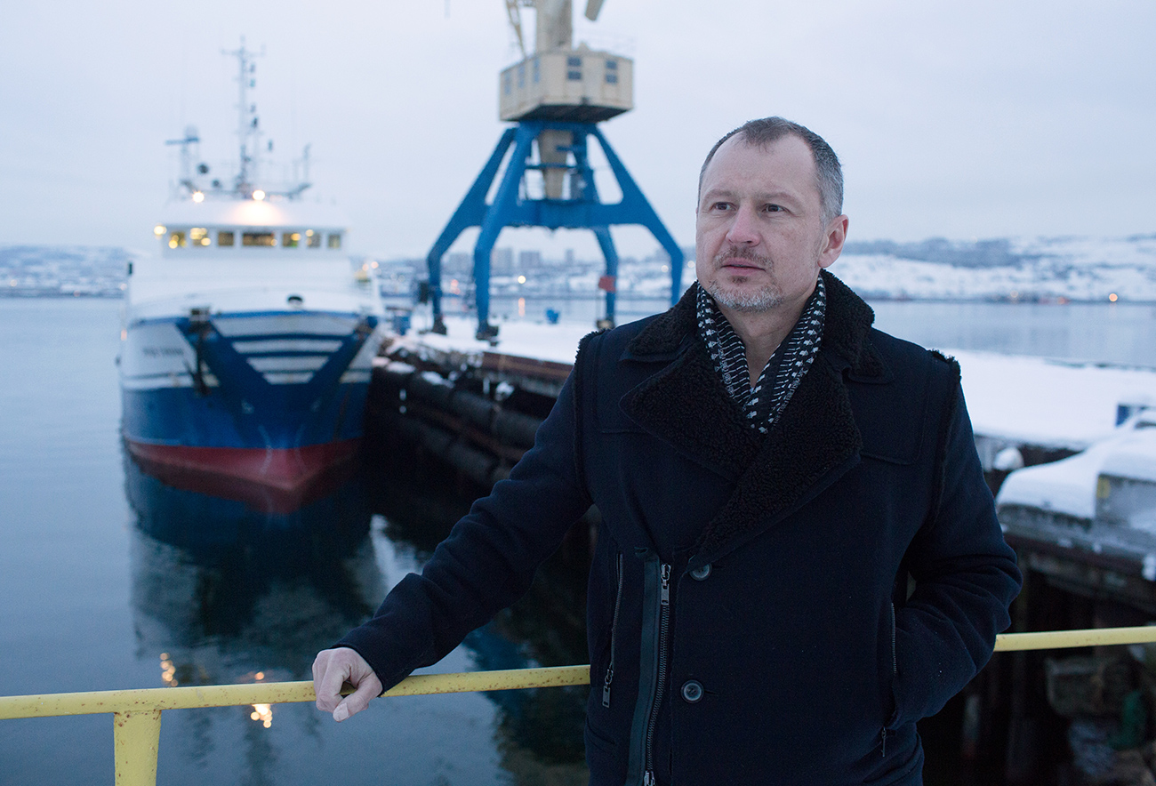 Orlov em frente a embarcação para pesca no cais de Murmansk, no Extremo Oriente russo