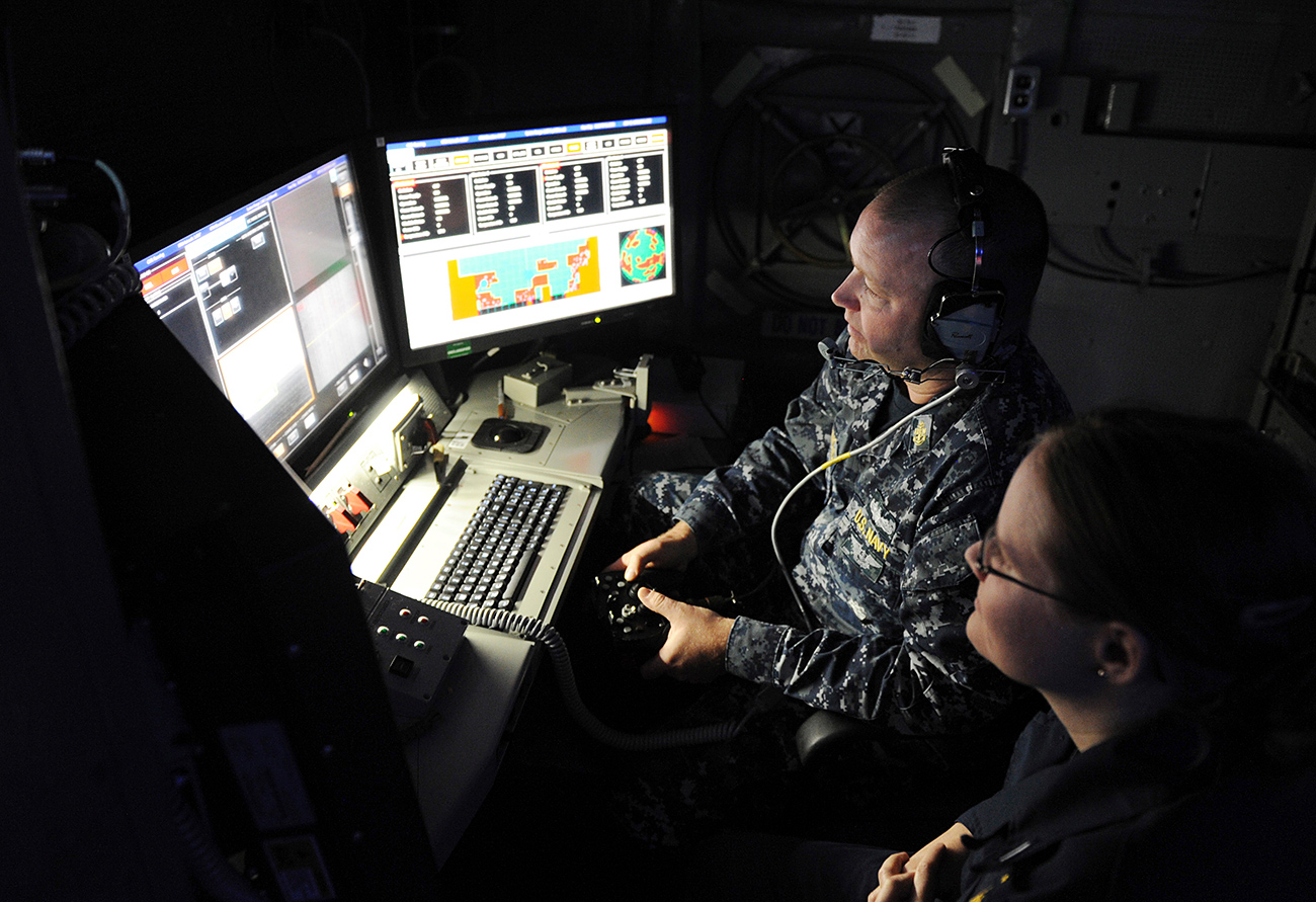Главниот контролор за лансирање Брет Ричмонд (лево) и помлад поручник Кејти Вудард управуваат со Ласерскиот оружен систем (Laser Weapon System LaWS) инсталиран на бродот УСС Понс во текот на оперативна демонстрација во Заливот. 16 ноември 2014 година.