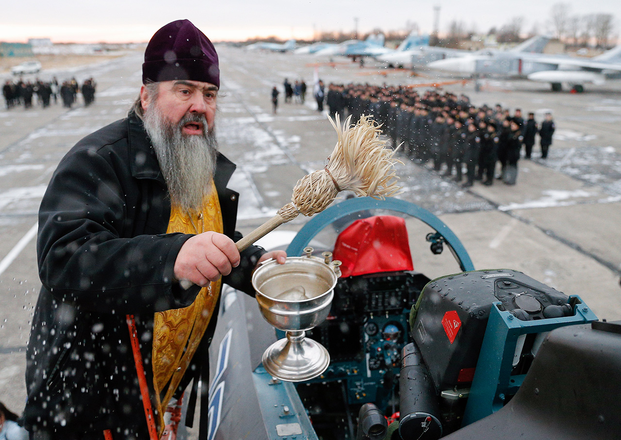 KALININGRAD REGION, RUSSIA - DECEMBER 13, 2016: A priest at a ceremony to welcome the Sukhoi Su-30SM fighter aircraft, the first one to join the Russian Navy Baltic Fleet, at the Chernyakhovsk air base.