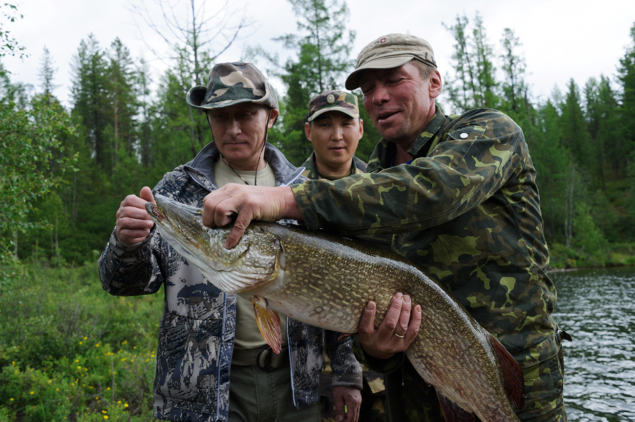 Russian President Vladimir Putin, left, on a fishing trip, 20 July 2013.