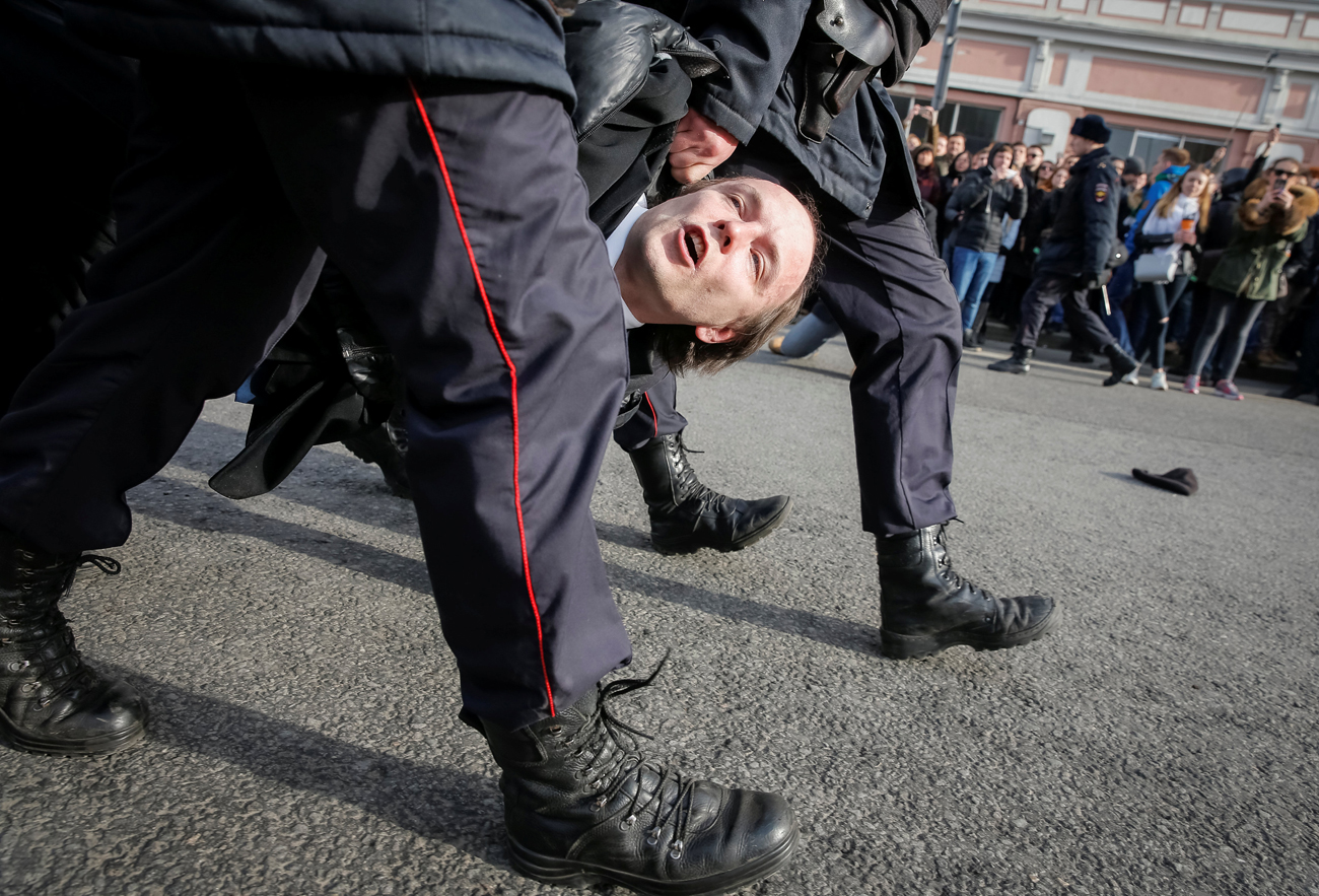 Law enforcement officers detain an opposition supporter during a rally in Moscow, Russia, March 26, 2017