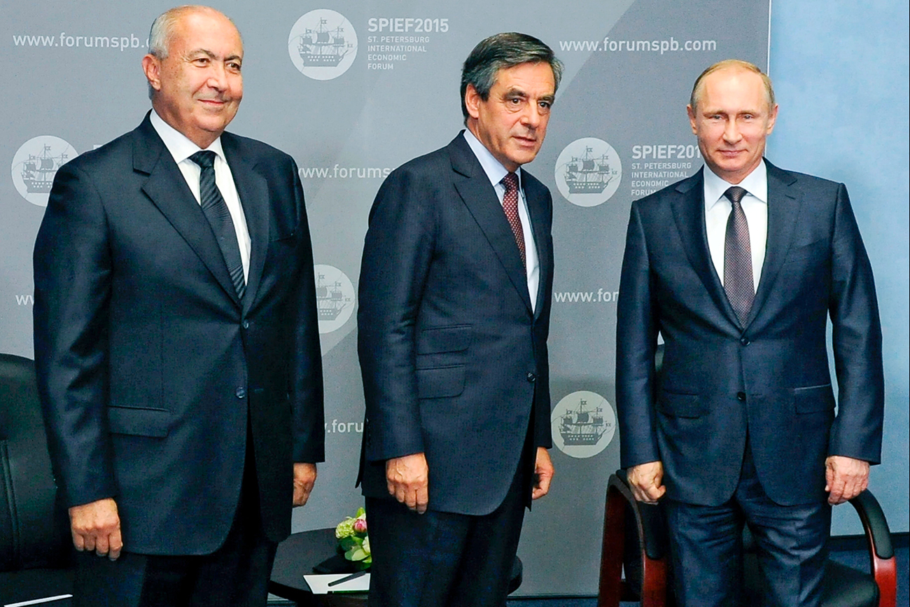 (От дясно наляво) Владимир Путин, бившият премиер на Франция Франсоа Фийон и бизнесменът Фуад Махзуми по време на среща на Икономическия форум в Санкт Петербург през 2015 г.