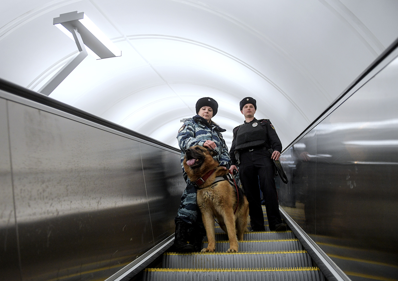 Moscow metro dog service center's employees patrol a Moscow metro station with a dog.
