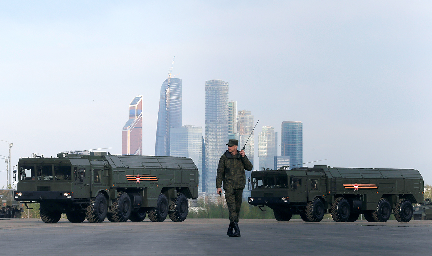 A Russian serviceman walks past Russian Iskander-M missile launchers before a rehearsal for the Victory Day parade, with the Moscow International Business Center also known as "Moskva-City" seen in the background, at a range in Moscow, Russia, May 5, 2016