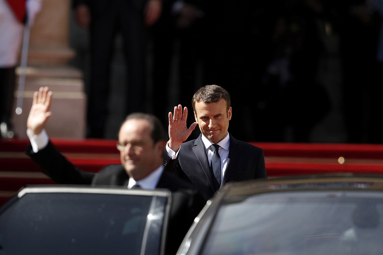 Former French President Francois Hollande (L) waves as President Emmanuel Macron (Rear) waves after the handover ceremony at the Elysee Palace in Paris, France, May 14, 2017.