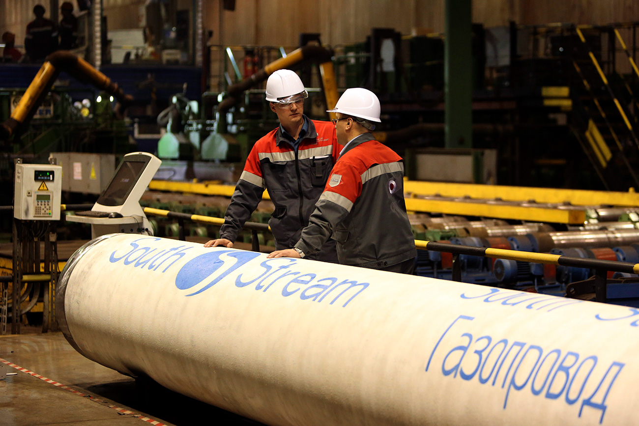 Employees stand near pipes made for the South Stream pipeline at the OMK metal works in Vyksa in the Nizhny Novgorod region