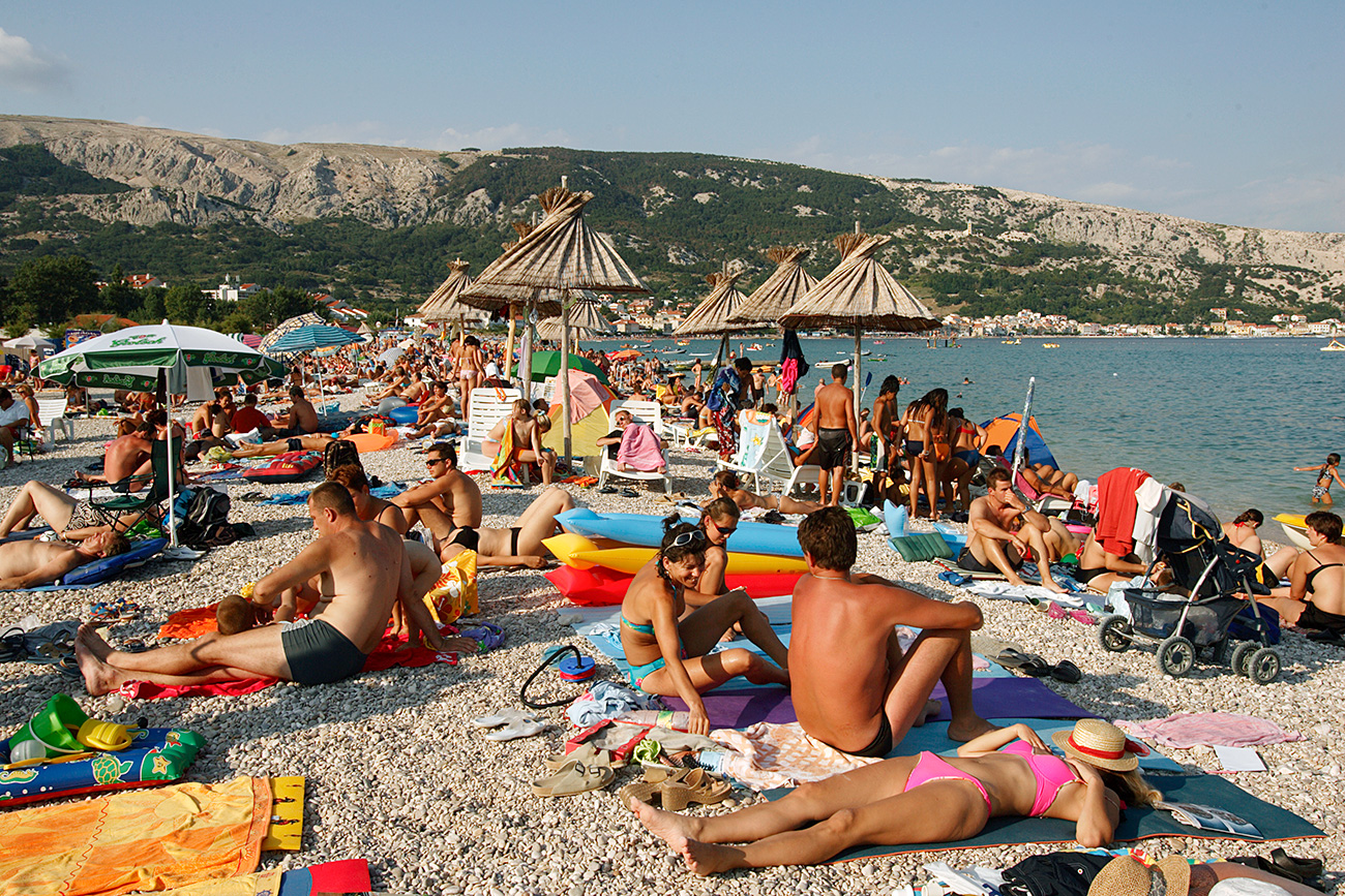 Crowds Sunbathing on Beach on the Adriatic in the town of Baska, on the island of Krk, Croatia.