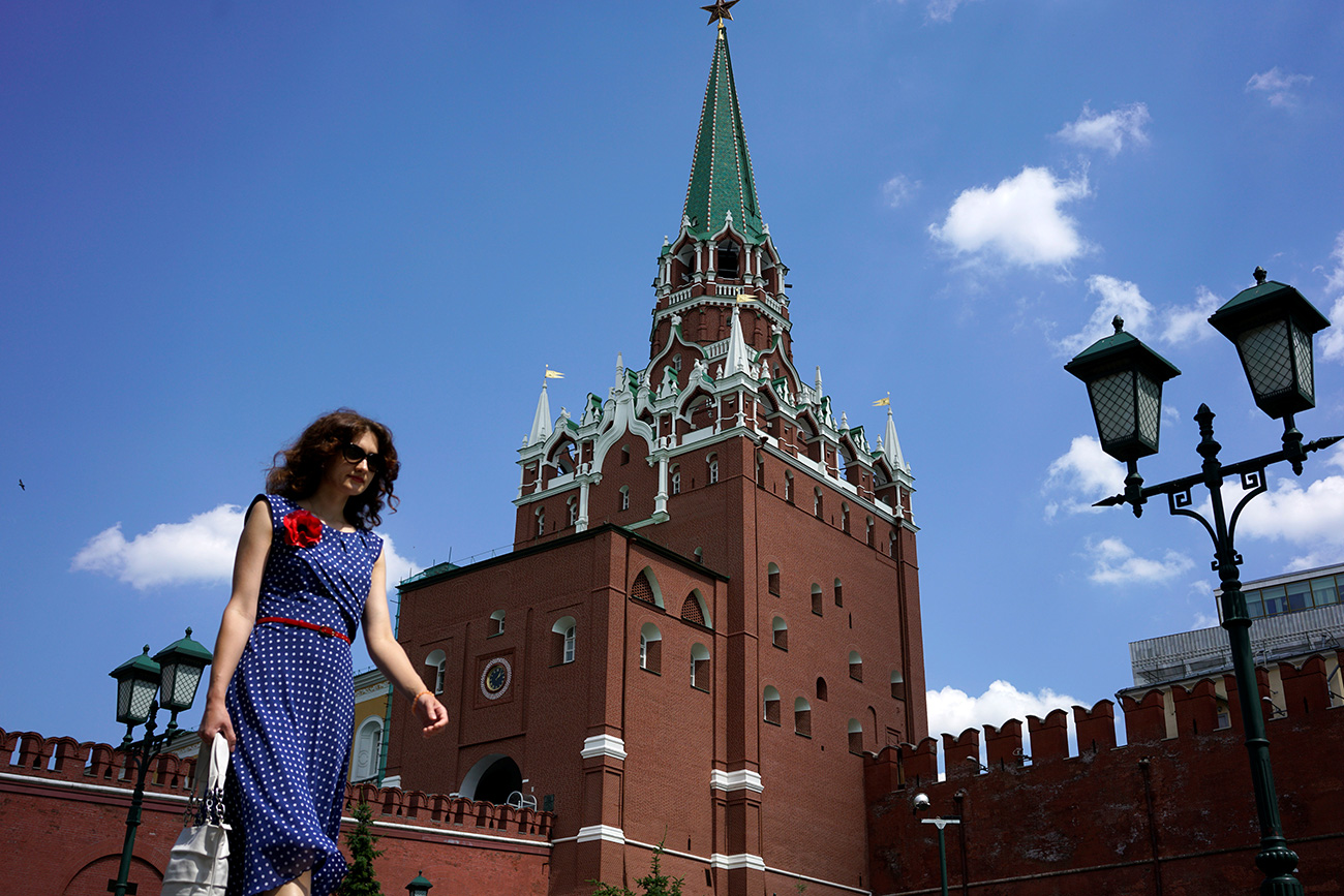 A woman walks at Alexandrovsky Garden as the Troitskaya (Trinity) Tower of Kremlin is seen in the background, in Moscow, Russia