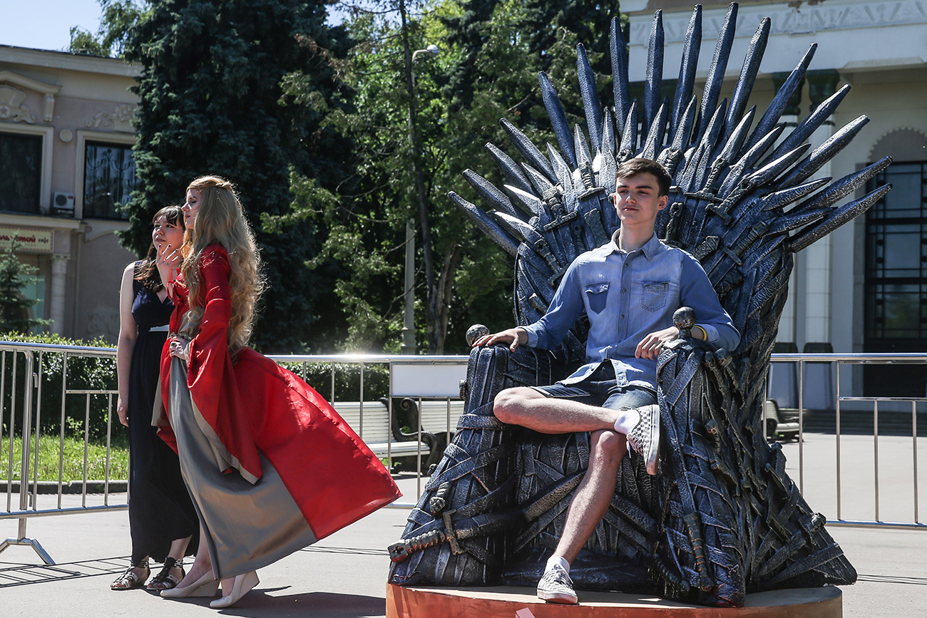 A young man poses for a photograph on a replica of the throne from the American television series "Game of Thrones" based on George R.R. Martin's best-selling book series "A Song of Ice and Fire" 