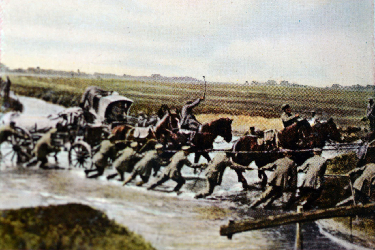 The contemporary colorized German propaganda photo shows German troops crossing a river on the Eastern Front in 1916. 