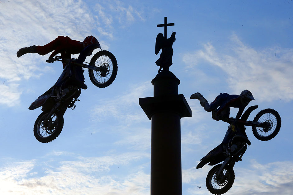 Bikers perform spectacular jumps in front of Alexander Column duringthe 'Adrenaline FMX Riders Motofreestyle-battle' at the Palace(Dvortsovaya) Square in St. Petersburg, Russia