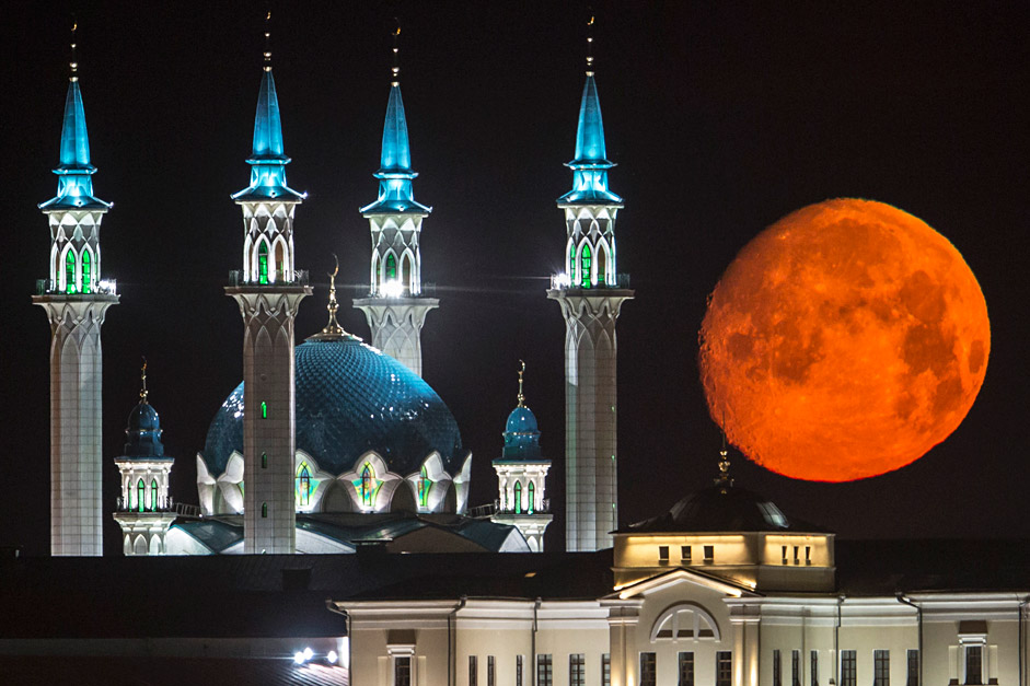 The full moon rises over the illuminated Kazan Kremlin with the Qol Sharif mosque illuminated in Kazan, the capital of Tatarstan, located in Russia's Volga River area about 450 miles east of Moscow, July 29