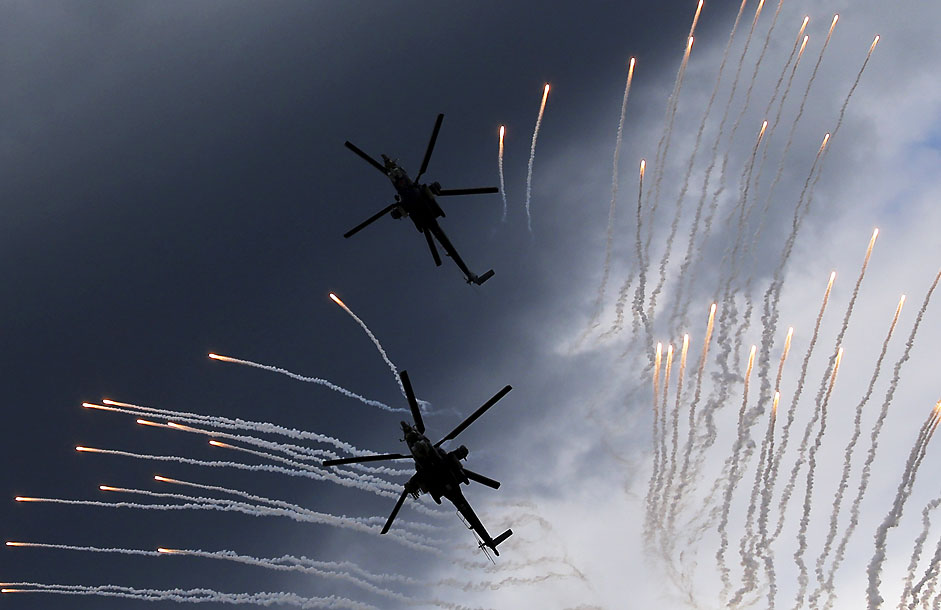 A Mi-28N (top) from the Berkuty (Golden Eagles) helicopter display team flies in formation during a performance before its hard touchdown at the "Aviadarts" military aviation competition at the Dubrovichi range near Ryazan, Russia, August 2, 2015. 