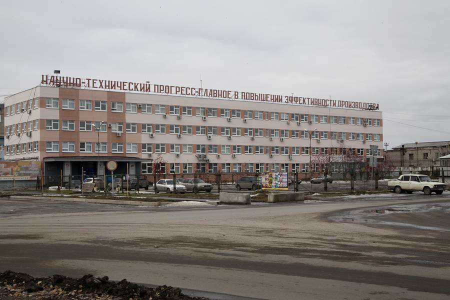 The text on the building reads: “Scientific and technological progress is the key to raising the level of production”