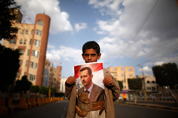 Seorang anak Suriah sedang memegang foto Presiden Bashar Assad di Sanaa.