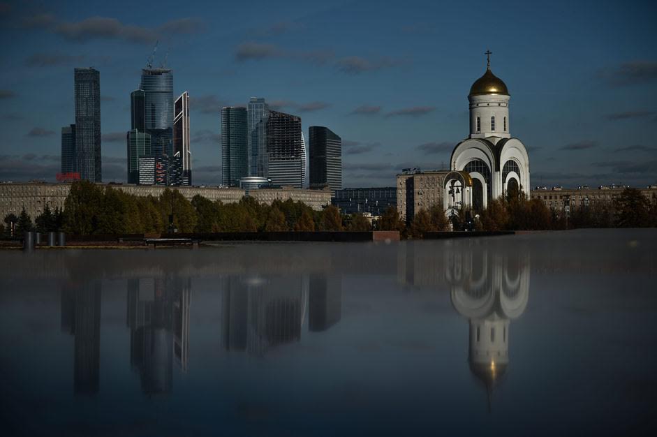 Die Kirche St. Georg auf dem Poklonnaja-Hügel in Moskau. Im Hintergrund sind die Wolkenkratzer des Finanzviertels Moskau City zu sehen.