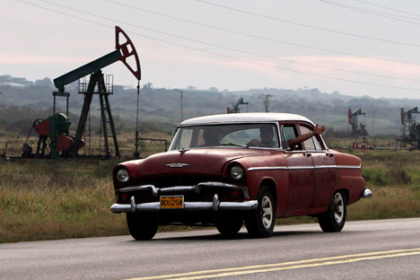 Russia will invest in a number of Cuban energy projects. Pictured: A man waving from his classic car as he drives by oscillating oil pumps operated by the state oil company Cuba Petroleos, Cupet, in Santa Cruz del Norte, Cuba. Source: AP