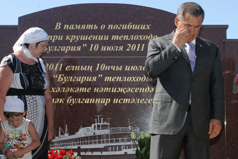 Tatarstan's President Rustam Minnikhanov (left) mourning the victims of the Bulgaria riverboat crash near the monument in the village of Syukeyevo. It includes an Orthodox church, a mosque and a marble slab bearing the names of the victims. Source: I