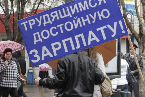 Russian trade unions criticize the country's  pension system and reform of the Labor Code. Pictured: A participant of a rally with the motto which reads: "Good Wage for Workers!"  Source: ITAR-TASS