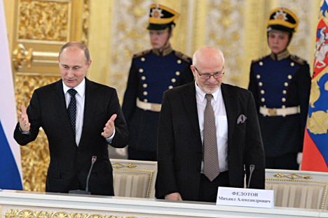 Russian President Vladimir Putin (left) and Chairman of Human Rights Council Mikhail Fedotov (right) greeting human rights activists. Source: Kommersant