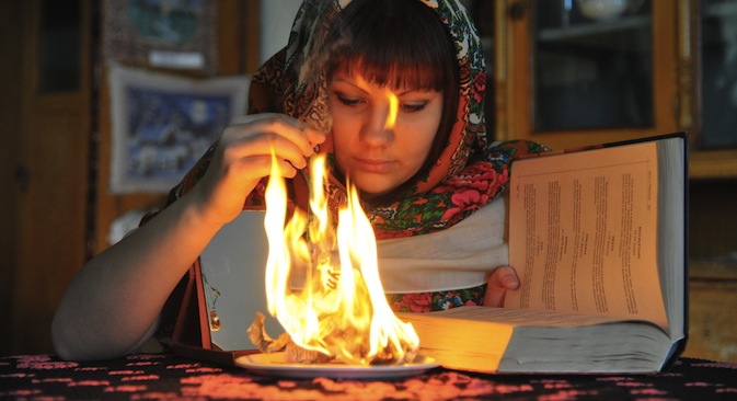 A girl trying out an age-old method to predict the future on the Christmas Eve. Source: RIA Novosti / Alexander Kondratyuk 