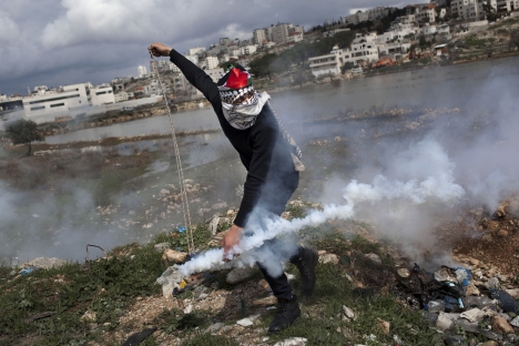 A Palestinian throws back a gas canister previously shoot by Israeli forces, not pictured, during a protest to support Palestinian prisoners, outside Ofer, an Israeli military prison near the West Bank city of Ramallah on Feb.19. Source: AP