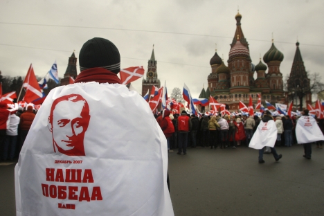 A member of the pro-Kremlin Nashi movement, wearing a cloak featuring the portrait of Russian President Putin and bearing the words, "Our Victory!" Source: AP