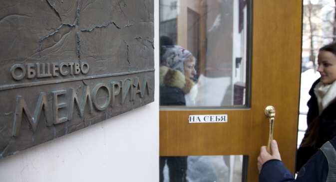 People talk near the entrance to human rights group Memorial's office, in Moscow, Russia, on Thursday, March 21, 2013, as prosecutors search for documents pertaining to all of its activities. Source: AP