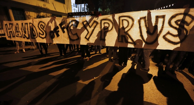 Anti-Troika protesters hold a "Hands off Cyprus" banner during a demonstration outside the EU offices in Nicosia on March 24. Source: Reuters