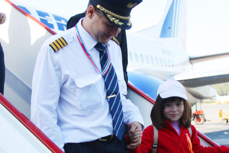 Stepping out: Pilot Evgeny Bogach gives a young patient a taste of the high life. Source: Transaero