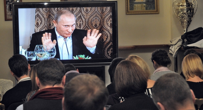 Vladimir Putin speaking from a TV screen during a Valdai club discussion. Source: Kommersant  