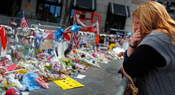 A woman looks over the memorial on Boylston Street Monday, April 22, 2013, in memory of the victims from the Boston Marathon bombing in Boston, Massachusetts. Source: Vostock Photo 