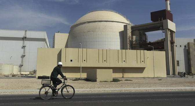 A worker rides a bike in front of the reactor building of the Bushehr nuclear power plant in Iran. Source: AP / Mehr News Agency / Majid Asgaripour