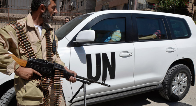 A Free Syrian Army fighter carries his weapon as he and fellow fighters escort a convoy of U.N. vehicles carrying a team of United Nations chemical weapons experts at one of the sites of an alleged chemical weapons attack in Damascus' suburbs of Zamalka, on August 28, 2013. Source: Reuters / Bassam Khabieh 