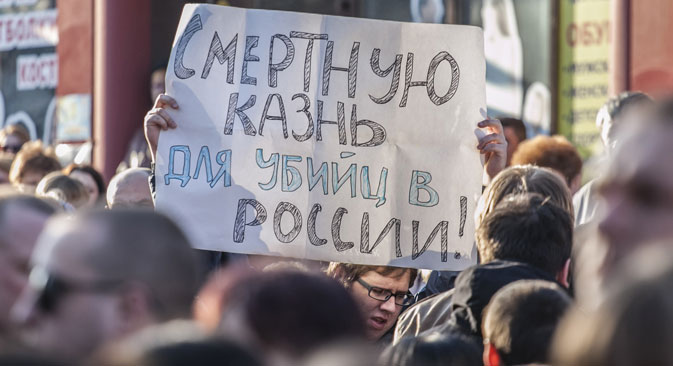 A Belgorod resident holds up a poster demanding capital punishment for those guilty of murder, at the site of a shooting incident on Narodny Bulvar in Belgorod. Six people were killed in the incident. Source: Alexandr Urivskiy / RIA Novosti